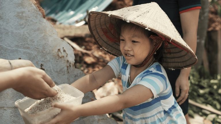 A little girl trying to get the last grains of rice from her destroyed house | Source: UNICEF
