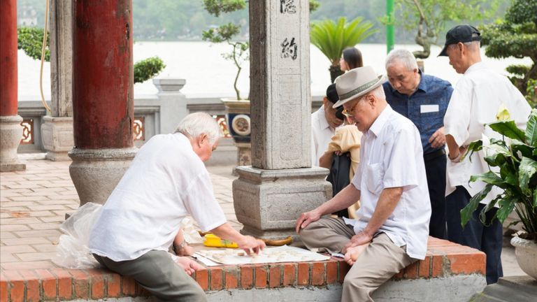 Older people playing Cờ tướng (Chinese chess) near Hoan Kiem Lake | Source: Shutterstock/fractalmonster