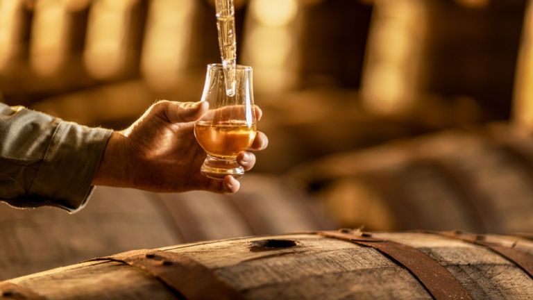 A distiller checks the quality and maturation progress of whisky with a dram glass. | Source : Về Để Đi.